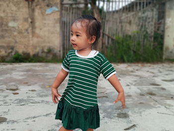 Cute boy looking away while standing outdoors