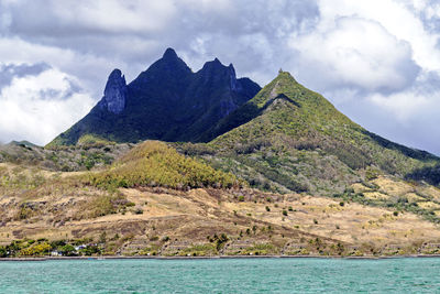 Scenic view of sea and mountains against sky