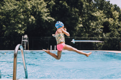 Full length of boy jumping in swimming pool