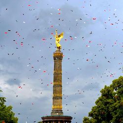 Confetti over victory column against cloudy sky