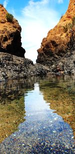 Rock formations by sea against sky