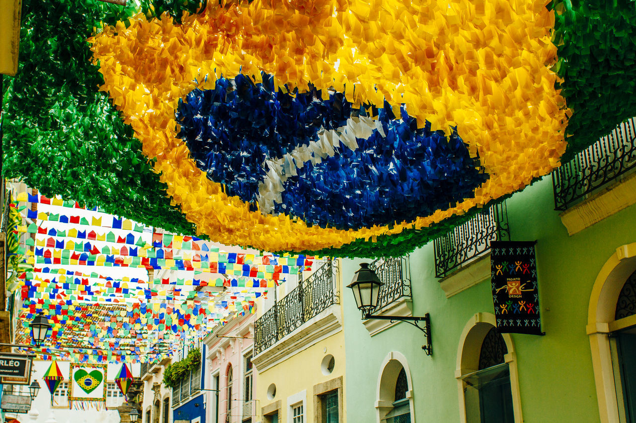 low angle view, architecture, built structure, multi colored, building exterior, yellow, decoration, colorful, day, no people, design, outdoors, art and craft, art, sky, building, creativity, window, pattern, text