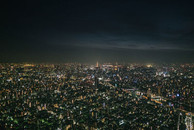 Illuminated cityscape against sky at night