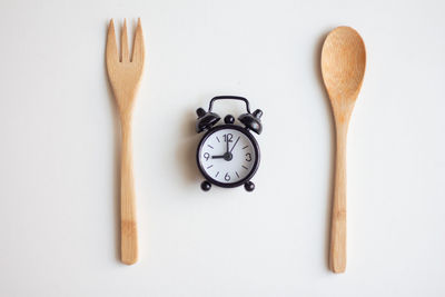 Directly above shot of clock on table against white background