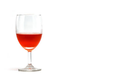 Red wine glass against white background