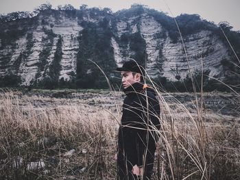 Man standing in field against mountain