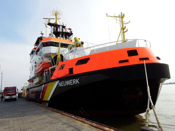 Ship moored at harbor against sky