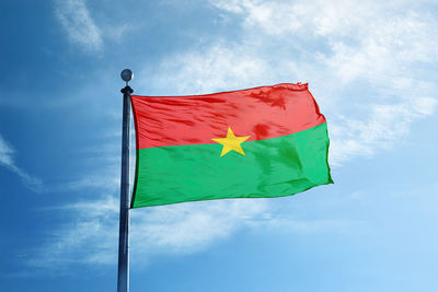 Low angle view of flag against blue sky