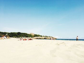 Scenic view of beach against clear blue sky