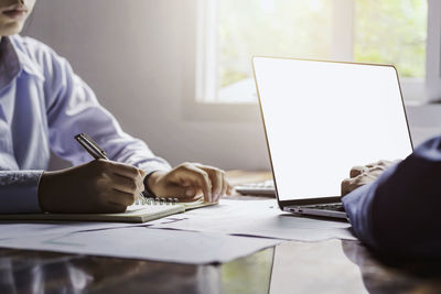 Rear view of man working on table