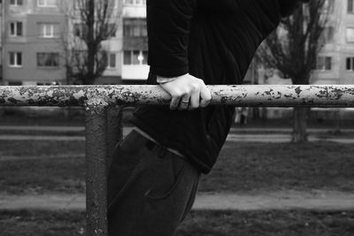 Man exercising on a street workout gym against soviet built structure