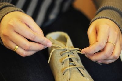 Midsection of woman tying shoelace