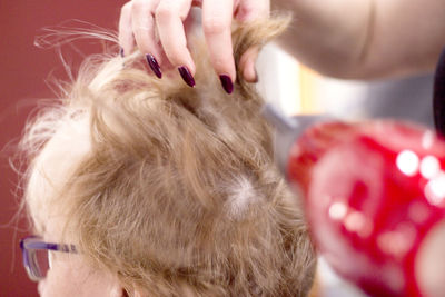 Cropped hand of beautician holding customer hair