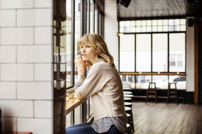 Woman looking away while sitting in bar