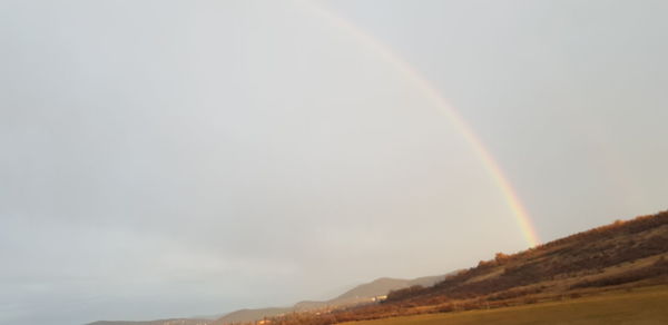 Low angle view of rainbow over mountain against sky