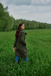 Rear view of woman walking on field