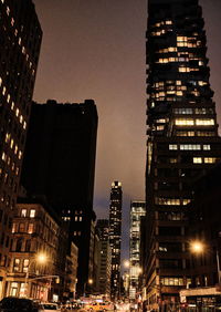 Illuminated buildings against sky at night