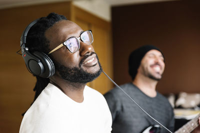 Close-up of man listening music through headphones