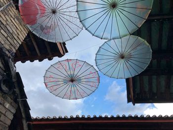 Low angle view of decoration hanging from roof against sky