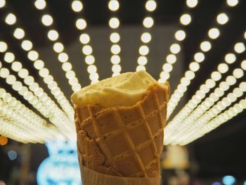 Close-up of ice cream against illuminated lighting equipment