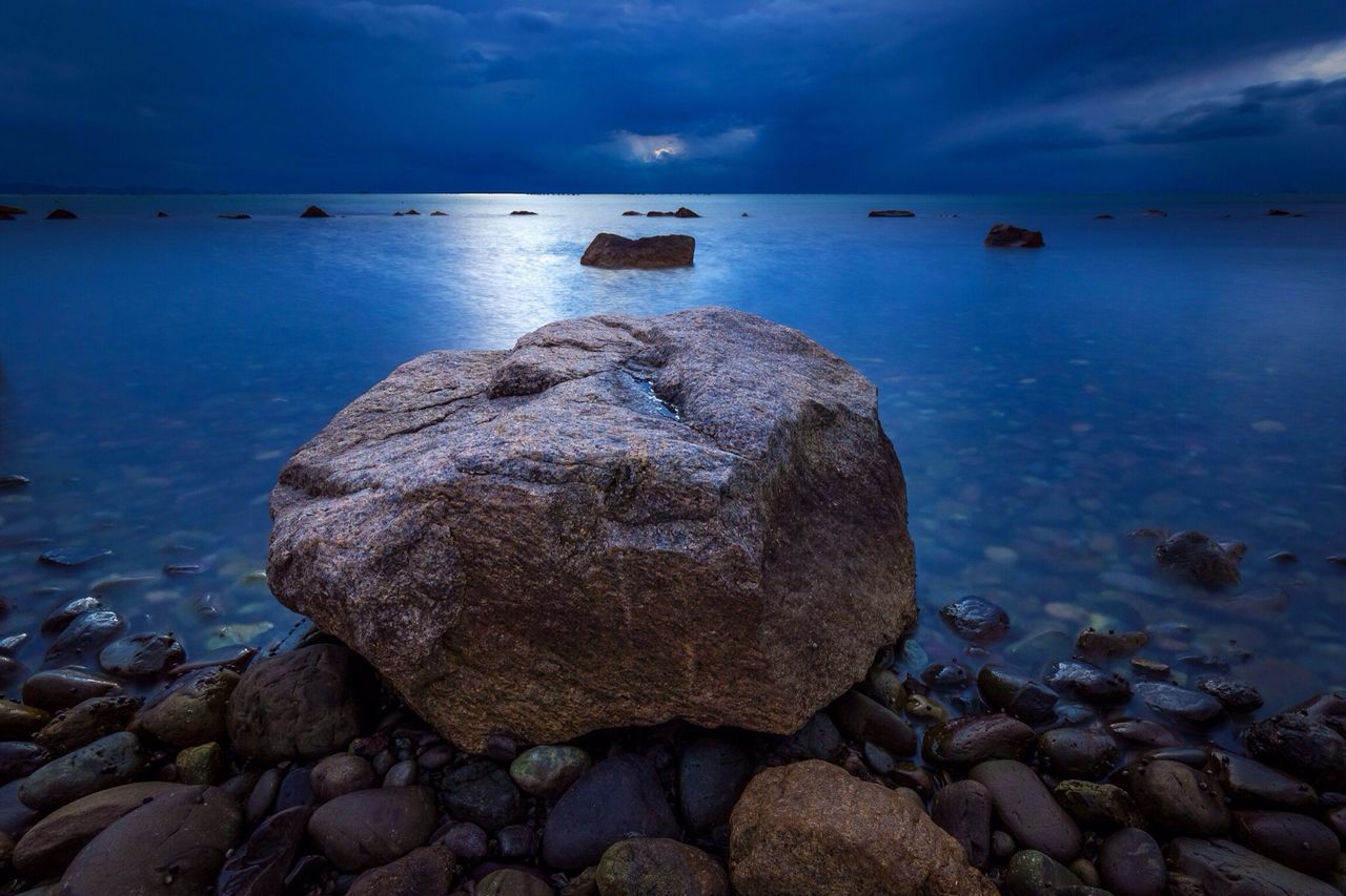 water, sea, rock - object, sky, tranquility, tranquil scene, scenics, beauty in nature, horizon over water, nautical vessel, rock, nature, reflection, transportation, shore, boat, cloud - sky, idyllic, stone - object, rock formation