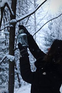 Close-up of woman holding lantern during winter