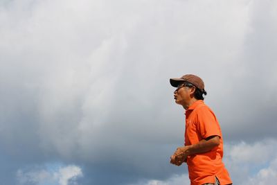 Side view of man standing against sky