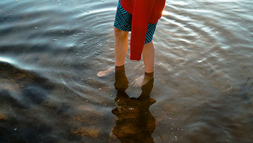 Low section of woman standing in lake