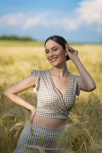 Portrait of young woman standing on field