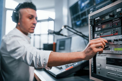 Setting the equipment. young man is indoors in the radio studio is busy by broadcast.