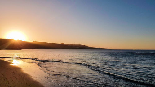 Scenic view of sea against clear sky during sunset