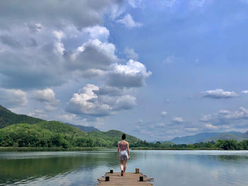 Man standing in lake against sky