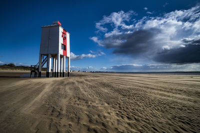 Lifeguard hut on beach against sky