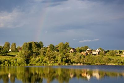 Scenic view of lake in front of trees against sky