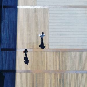 High angle view of people walking on wooden footpath
