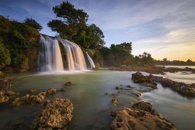 Scenic view of waterfall against sky