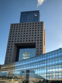 Low angle view of modern building against blue sky