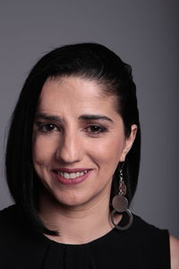 Portrait of smiling woman against gray background