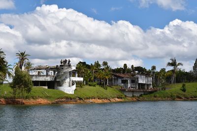 Buildings by river against sky