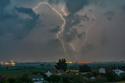 Lightning over cityscape against dramatic sky