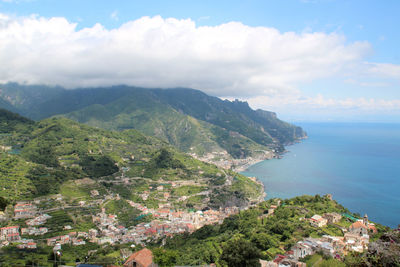 Scenic view of sea by townscape against sky