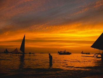 Silhouette sailboats on sea against sky during sunset