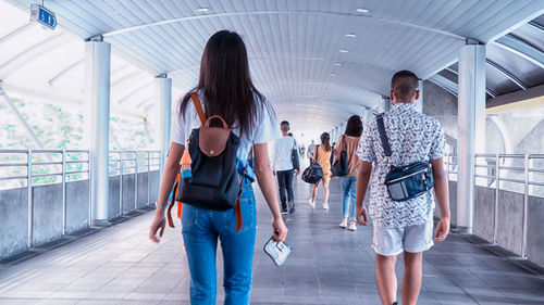 Rear view of people walking in corridor