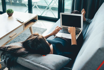 Rear view of people sitting on laptop