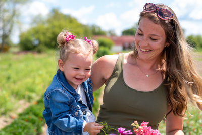 Cute smiling girl with mother outdoors