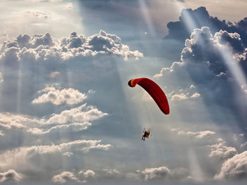 Low angle view of person paragliding against sky