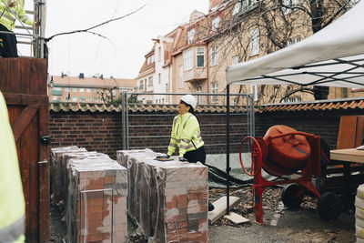 Female building contractor talking with male worker working at construction site