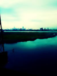 Scenic view of river against sky in city