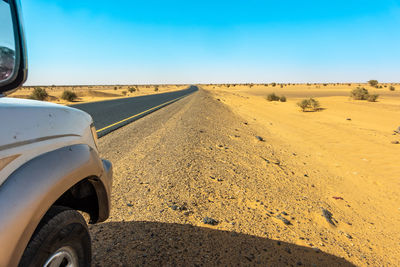 Driving on the grey asphalt road throw the sandy sahara of sudan