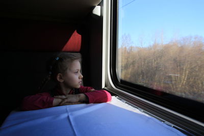 Portrait of little girl seen through train window